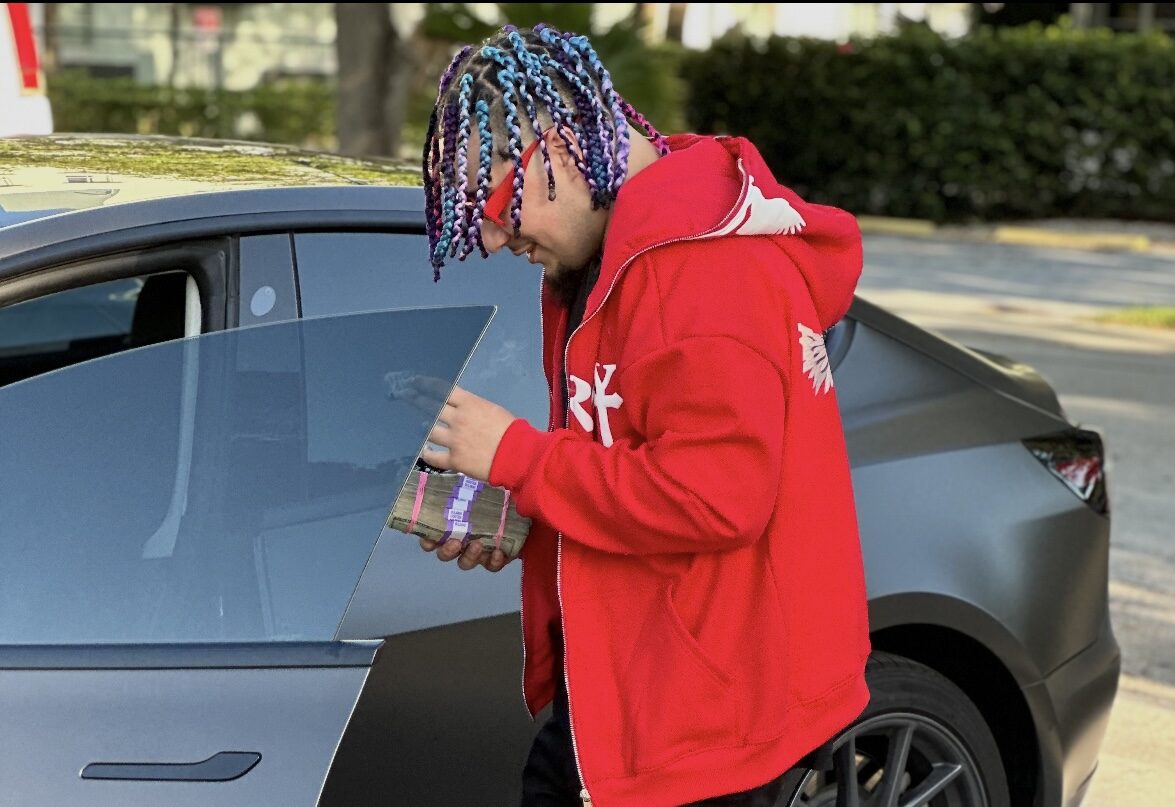 a man with braids looking at a bag of money